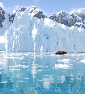 Zodiac cruising past icebergs in Antarctica