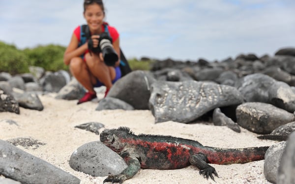 A tourist in the Galapagos with a camera, a key item on your cruise packing list
