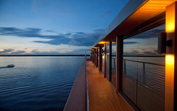aqua expeditions' aqua mekong on the mekong at sunset 