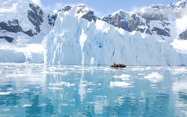 Zodiac cruising past icebergs in Antarctica
