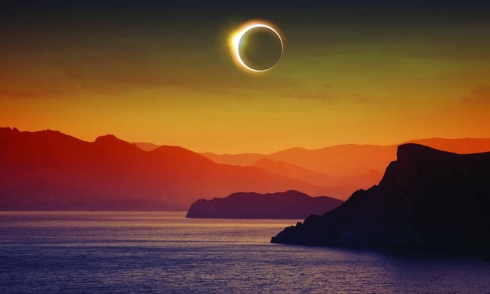 Solar eclipse over mountains and sea