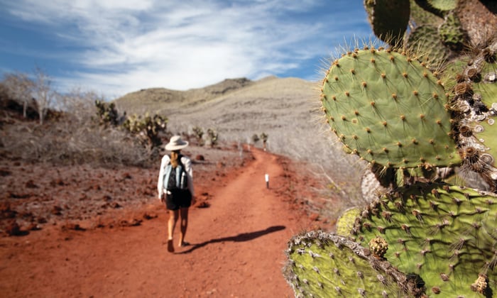 Silversea Expeditions guest wearing daypack on Rabida Island, Galapagos