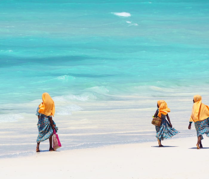 women walking on the beach in zanzibar indian ocean