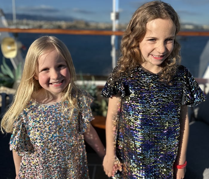 Alex Loizou's daughters dressed for dinner on a family cruise on Explora Journeys' Explora I