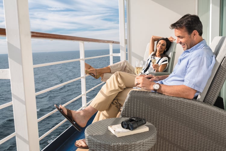 Regent guests relaxing on the balcony of one the best cruise ship suites at sea